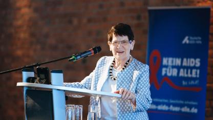 Rita S&uuml;ssmuth am Redepult, Hintergrund: Schriftzug "Kein Aids f&uuml;r alle!"