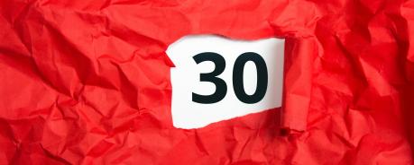 30 Rotes Geschenkpapier aufgerissen, darunter die Zahl 30