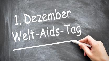Das Bild zeigt eine Tafel auf der "1. Dezember Welt-Aids-Tag" steht. 